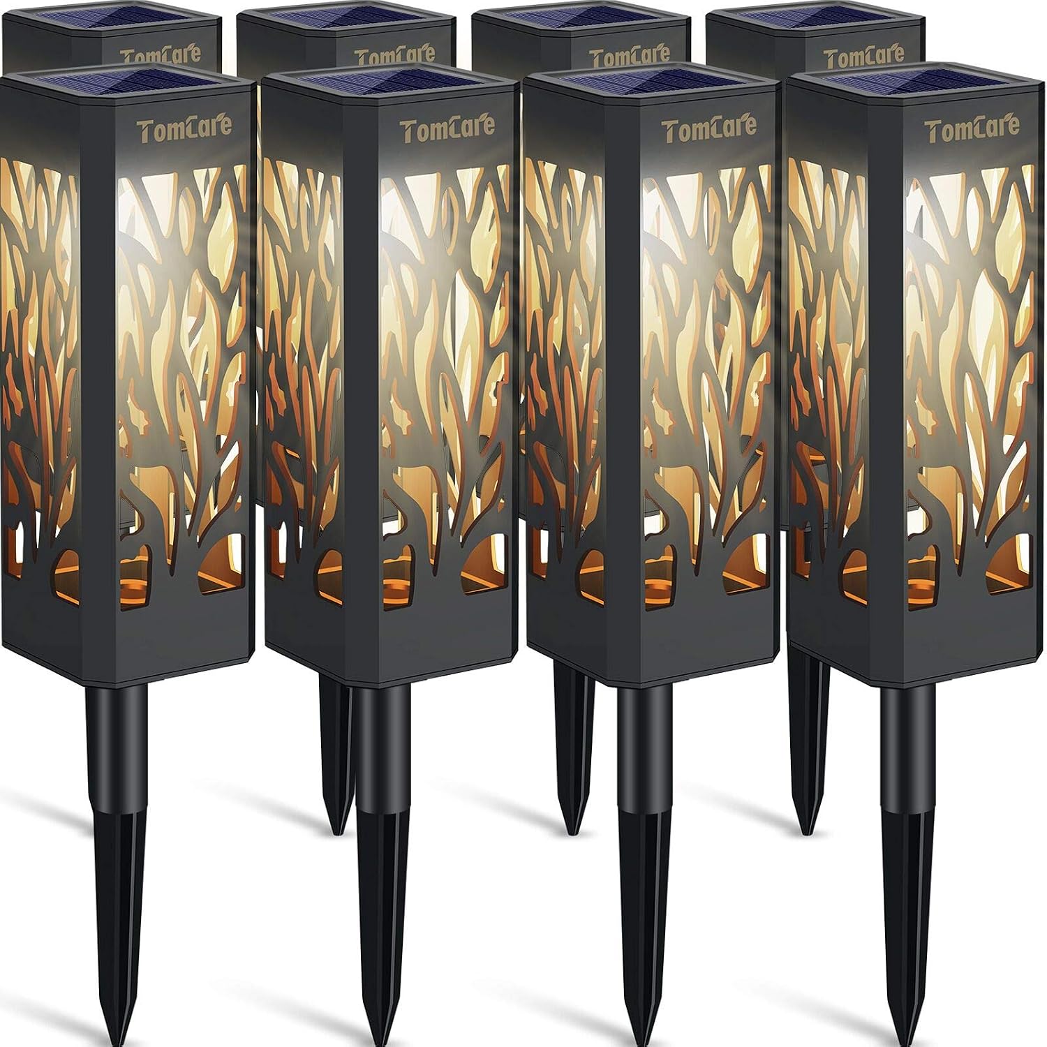 Eight TomCare solar pathway lights with square black housings, leaf-shaped cut-outs glowing warm white and pointed ground stakes